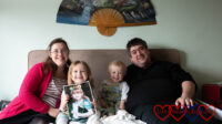 Me, Sophie (holding a picture of Jessica), Thomas and Daddy sitting on a bed together