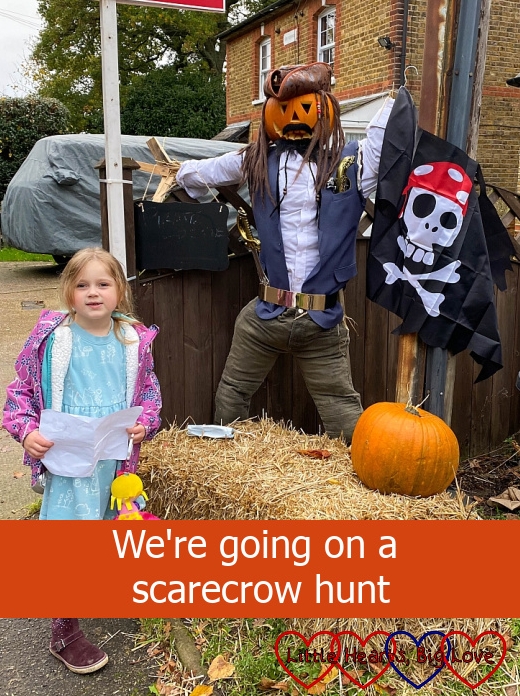 Sophie with a scarecrow dressed as a pirate captain - "We're going on a scarecrow hunt"
