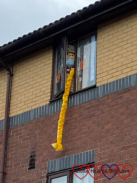 A Rapunzel scarecrow looking out of the window of a top-floor flat