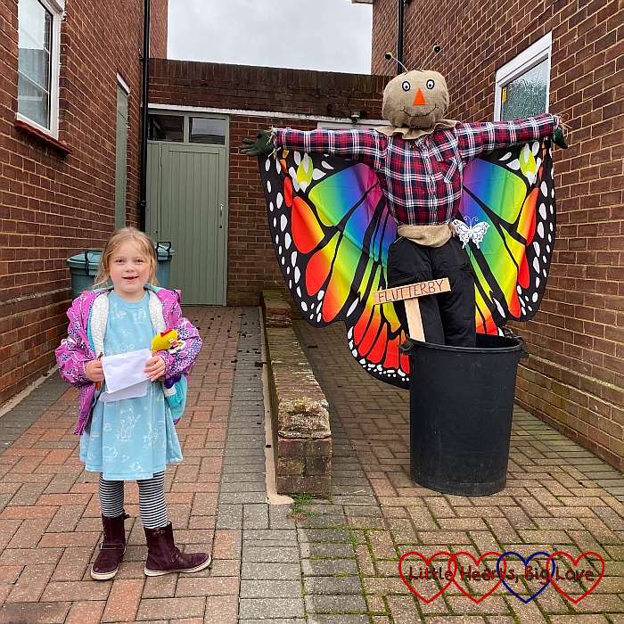 Sophie next to a scarecrow with brightly coloured butterfly wings