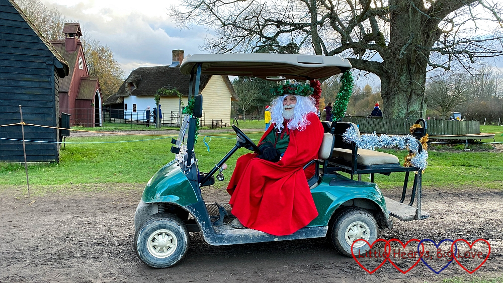 Father Christmas riding a golf buggy covered in tinsel