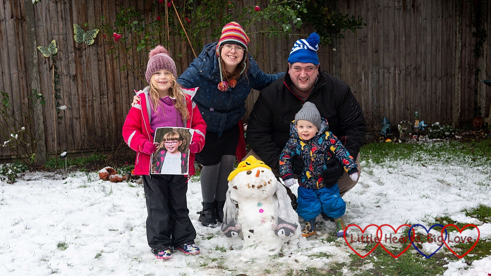 Sophie (holding a photo of Jessica), me, hubby and Thomas out in the garden in the snow with Sophie's snowman in front of us