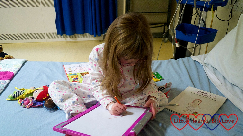 Jessica on her bed in the cardiac ward drawing a picture