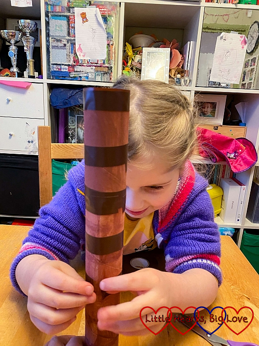 Sophie taping brown-painted toilet roll tubes together with brown tape
