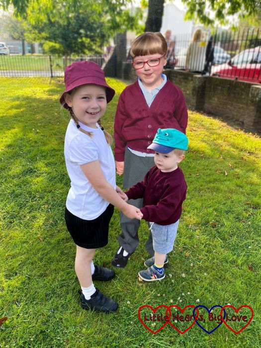 Sophie and Thomas holding hands outside school with Jessica photoshopped to be standing behind them