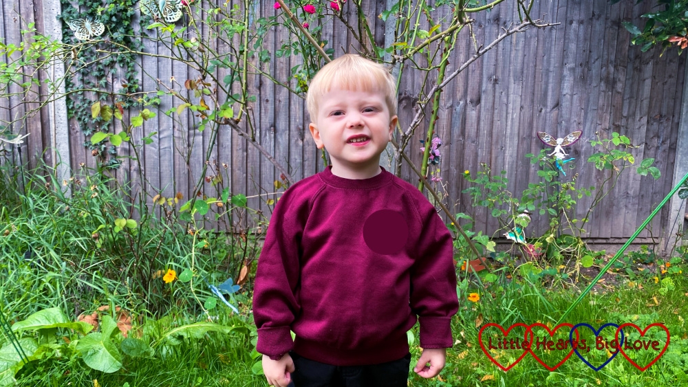 Thomas in the garden wearing his preschool jumper