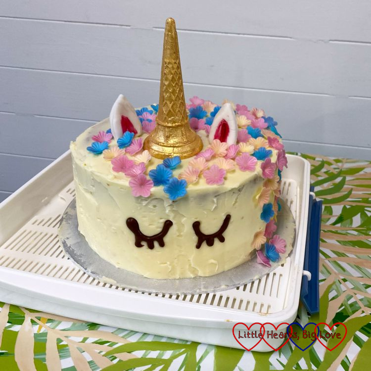 A unicorn birthday cake with edible flowers for the mane and a gold-sprayed ice-cream cone for the horn