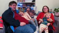 Hubby, Sophie, me and Thomas sitting on the sofa with Jessica's photo cushion behind us