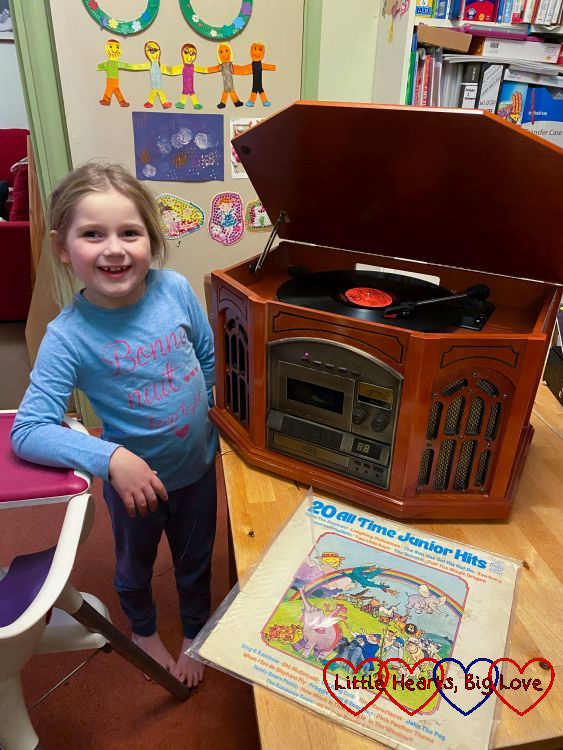 Sophie standing next to a record player with the album sleeve for '20 all-time junior hits' in front