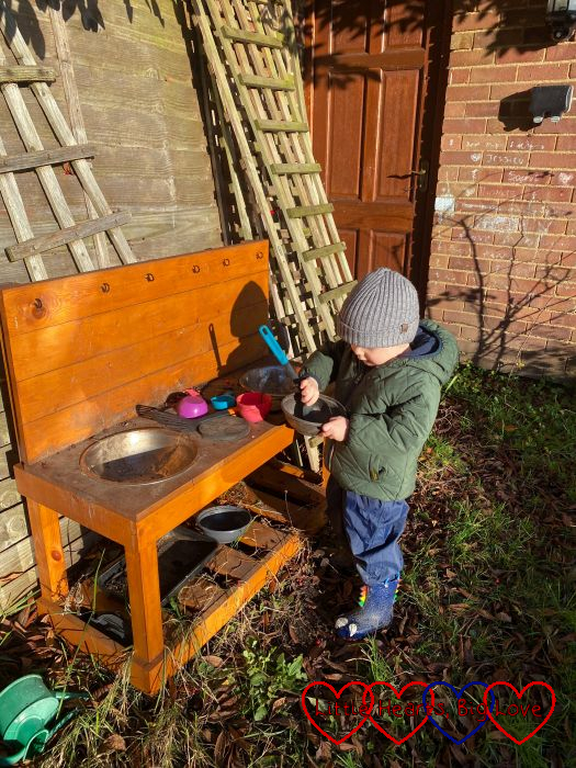 Thomas playing in the mud kitchen in the garden