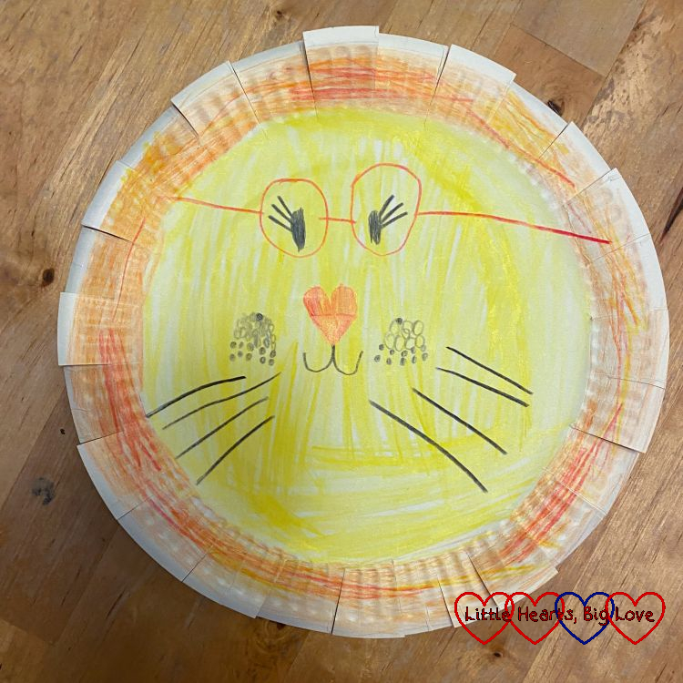 A paper-plate lion with red glasses