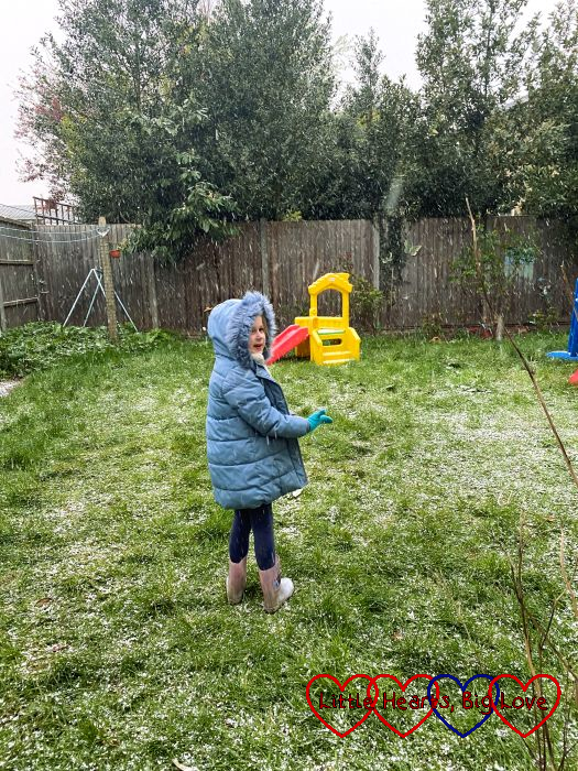 Sophie standing in the garden with snow falling around her