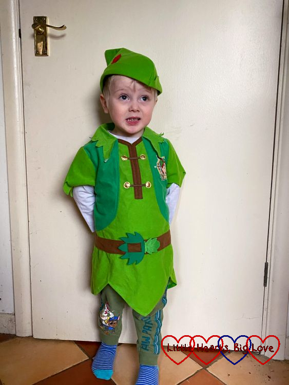 Thomas dressed as Peter Pan, standing in front of a door