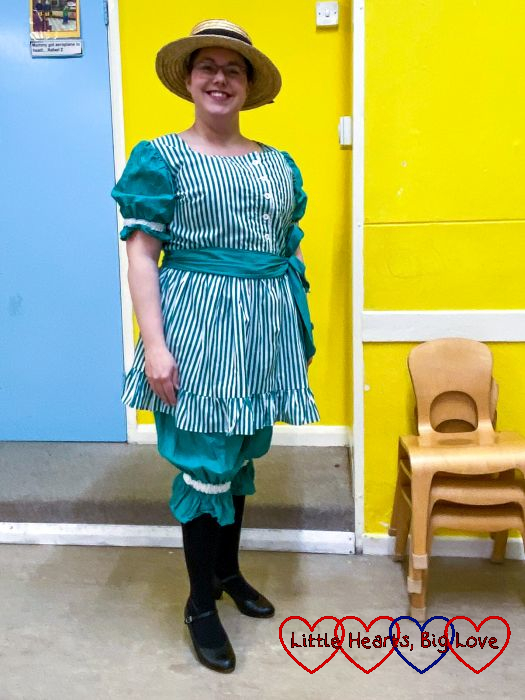 Me wearing a green and white striped Victorian bathing dress with a straw boater hat