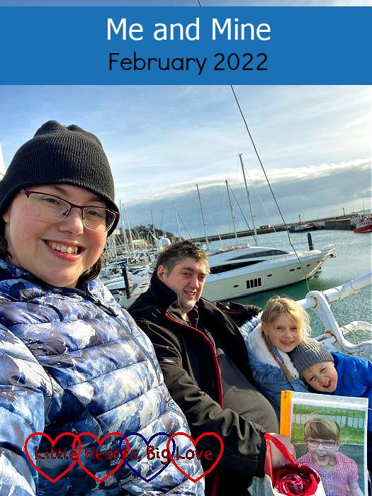 Me, my husband (holding a photo of Jessica), Sophie and Thomas sitting on a bench at Torquay with the sea and boats in the background - "Me and Mine - February 2022"