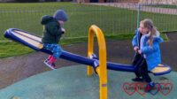Sophie and Thomas on a seesaw at the park