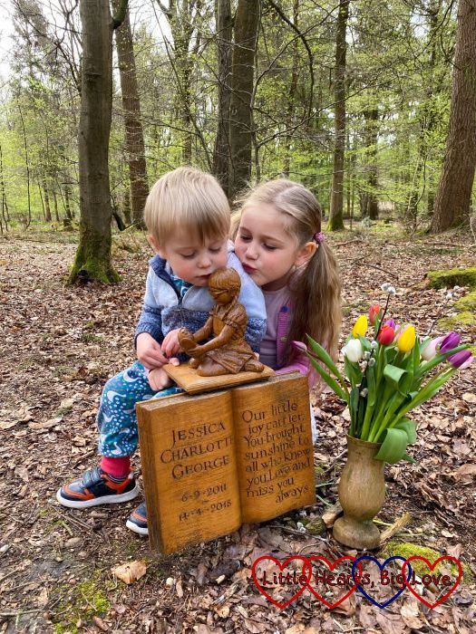 Sophie and Thomas kissing the wooden sculpture of Jessica at Jessica's forever bed