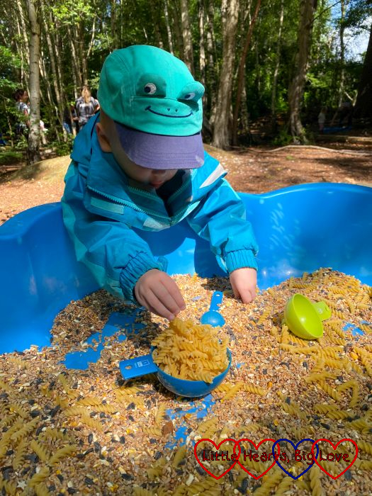 Thomas playing in the sensory pasta and seed tray at Tots Go Wild