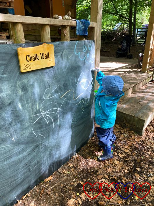 Thomas writing on the chalk wall at Tots Go Wild
