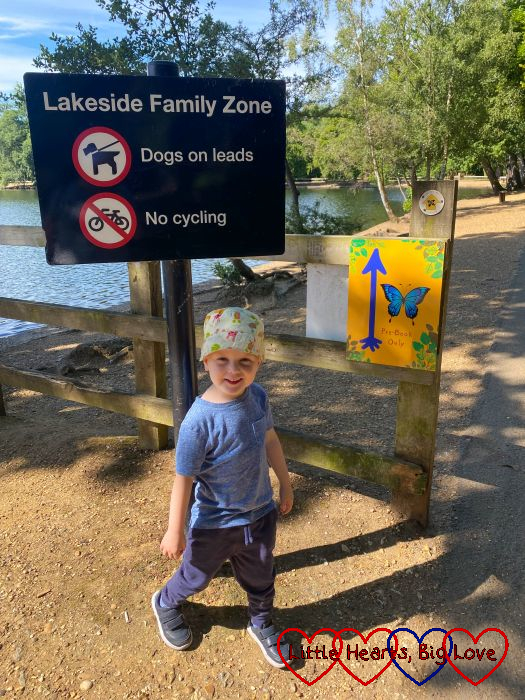 Thomas standing in front of a butterfly sign showing the way to Tots Go Wild