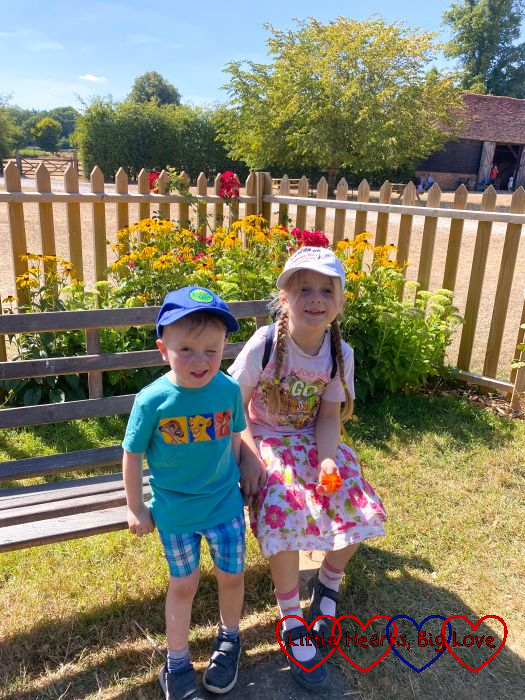 Sophie and Thomas sitting in a bench in front of a flower bed