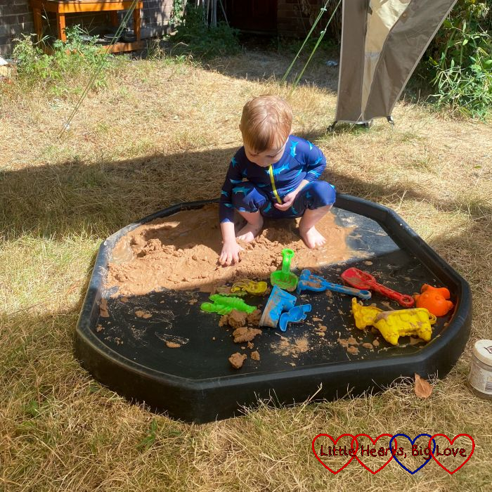 Thomas playing with sand in the tuff tray