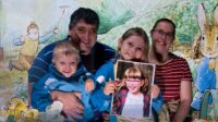 Hubby, Thomas, Sophie (holding a picture of Jessica) and me in front of a Beatrix Potter themed backdrop
