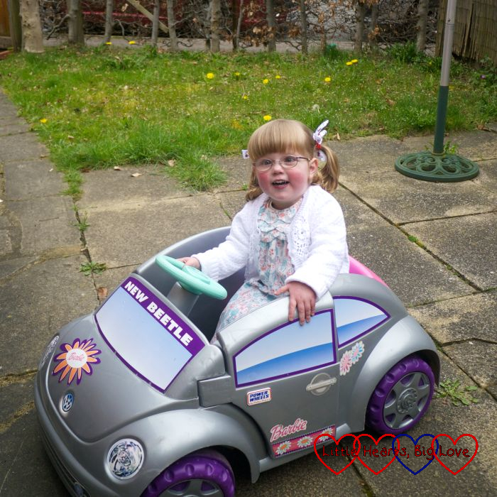 A two-year old Jessica sitting in a toy VW Beetle