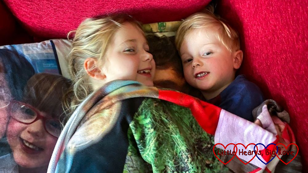 Sophie and Thomas snuggled under 'the Jessica blanket' with Jessica's photo cushion next to them