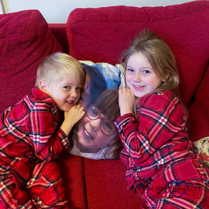 Sophie and Thomas cuddling on the sofa next to a photo of Jessica from her photo blanket