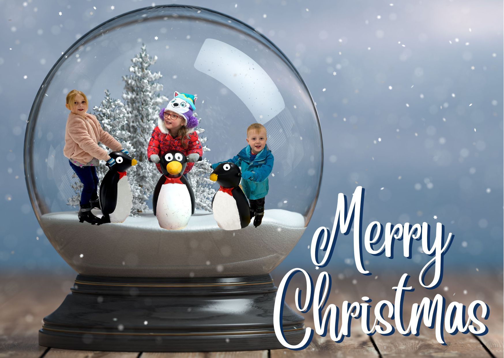 A Photoshopped picture of Jessica, Sophie and Thomas holding ice-skating penguins inside a snow globe with the words "Merry Christmas"