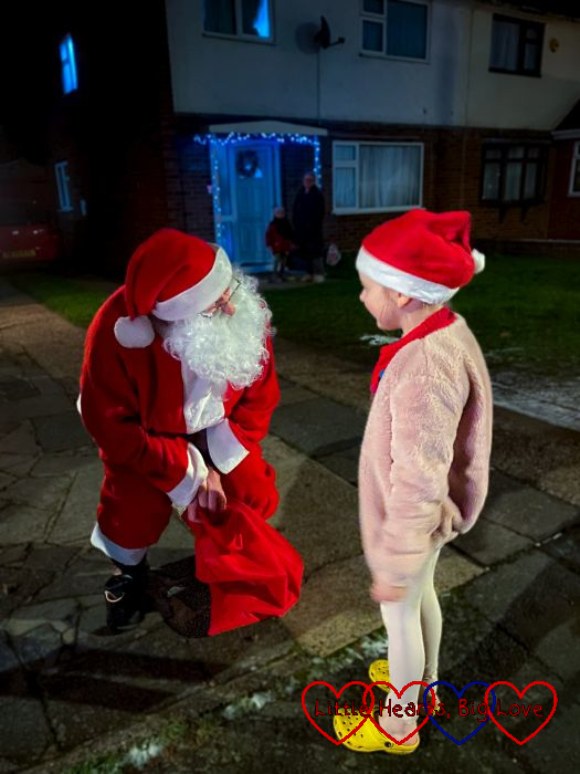 Sophie talking to Father Christmas outside a house