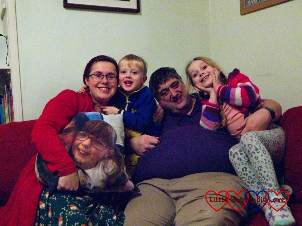Me (holding the photo cushion with Jessica's photo), Thomas, Daddy and Sophie sitting on the sofa together