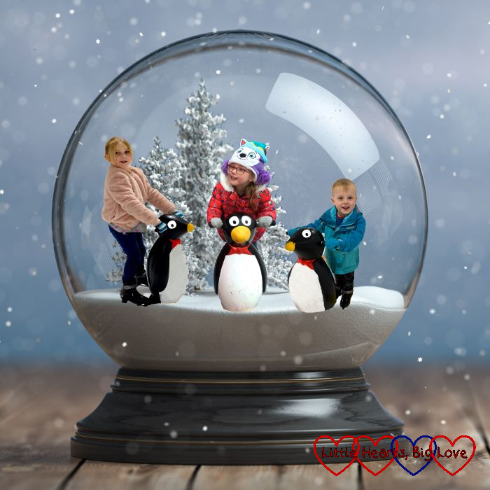 A Photoshopped picture of Jessica, Sophie and Thomas holding ice-skating penguins inside a snow globe