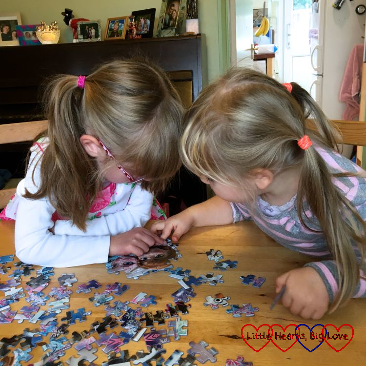 Jessica and Sophie sitting at the table doing a jigsaw together