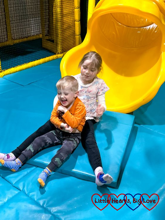 A smiling Sophie and Thomas at the bottom of a slide
