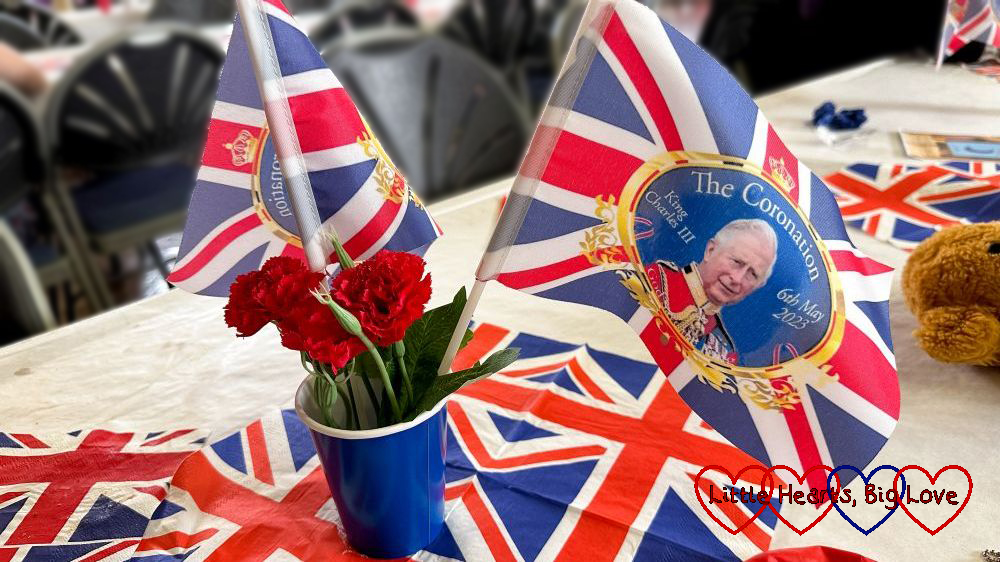 Flags and Union Jack napkins on a table to celebrate the King's Coronation