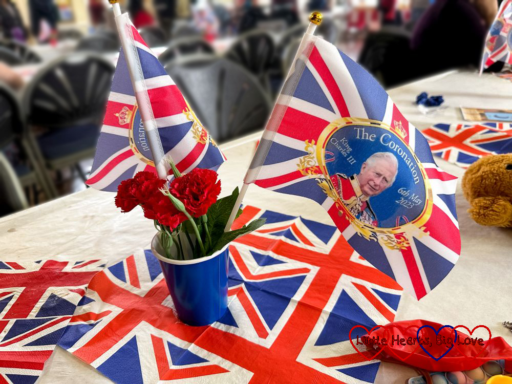 Flags and Union Jack napkins on a table to celebrate the King's Coronation