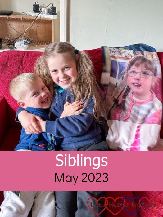 Sophie and Thomas having cuddles on the sofa next to a photo of Jessica from her photo-blanket - "Siblings - May 2023"