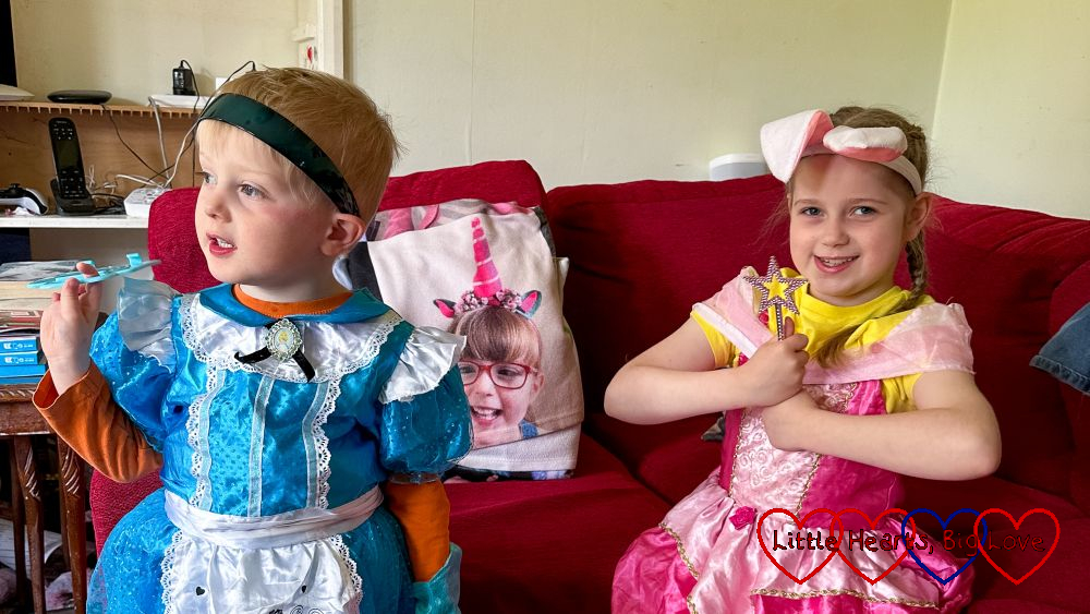Sophie and Thomas wearing princess dresses with Jessica's photo blanket on the sofa between them