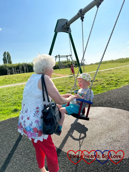 My mum pushing Thomas on a swing at the park