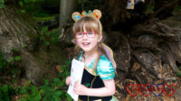 Jessica in the woods wearing a princess dress and teddy bear ears