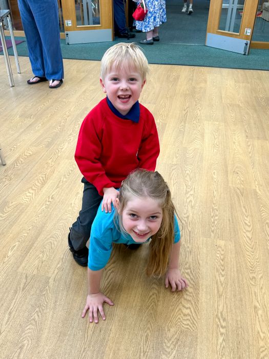 Sophie crawling across the floor with Thomas sitting on her back