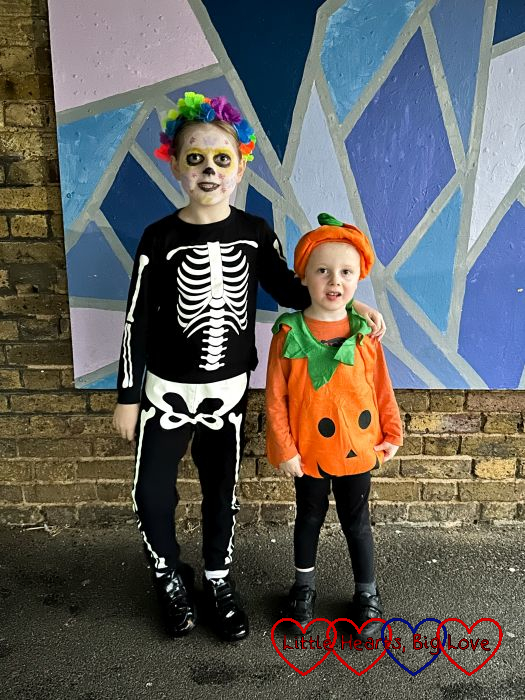Sophie dressed as a skeleton with her face painted as a skull with flower patterns and Thomas dressed as a pumpkin