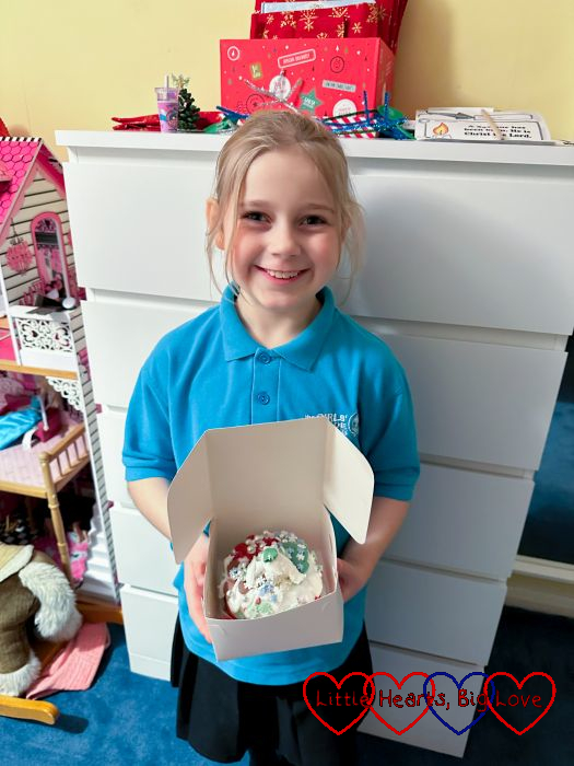 Sophie holding a cake box with a Christmas cake inside