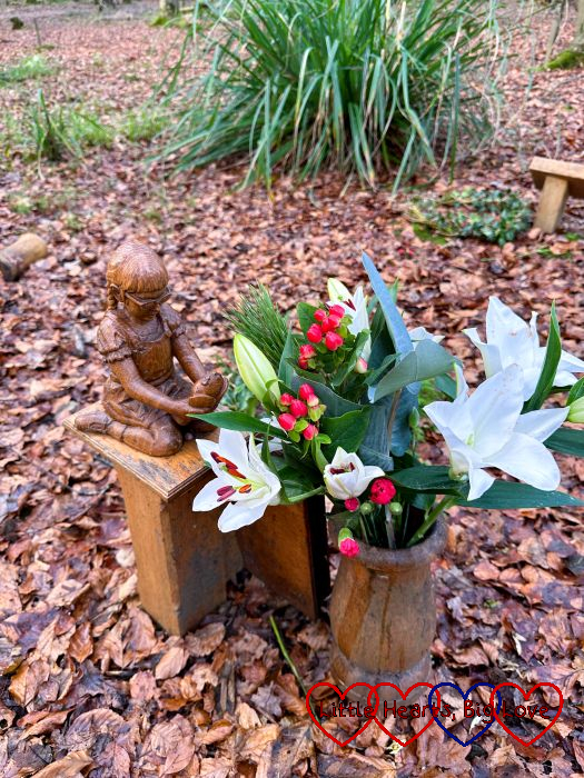 White lilies with red berries, fir and eucalyptus leaves in the wooden vase at Jessica's forever bed