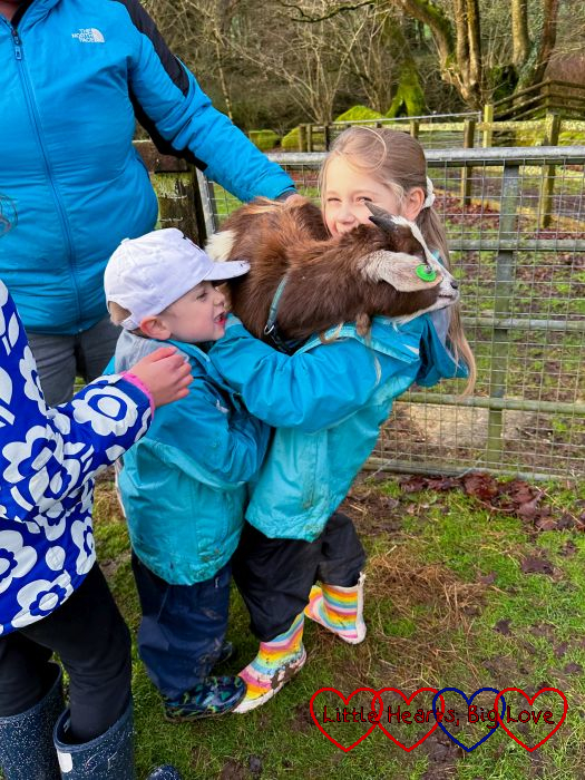 Sophie and Thomas holding a goat