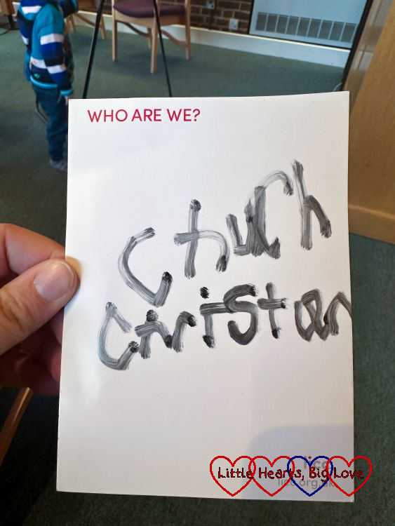 The words 'church' and 'Christian' written on a postcard with the question 'Who are we?'
