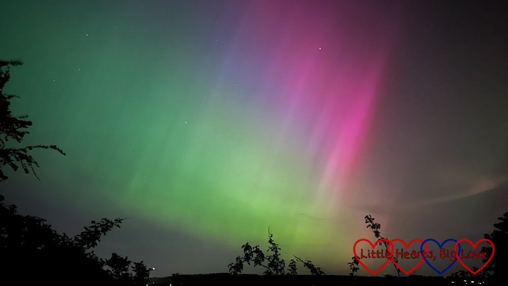 Pink, purple and green aurora borealis in the night sky