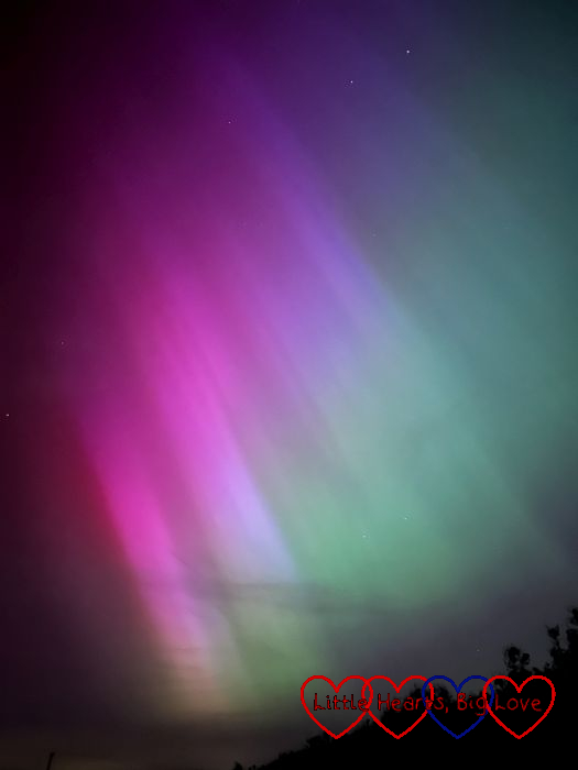 Pink, purple and green aurora borealis in the night sky